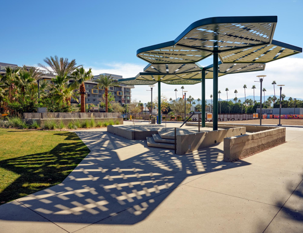 An example of a shade structure over concrete sitting areas in a public park