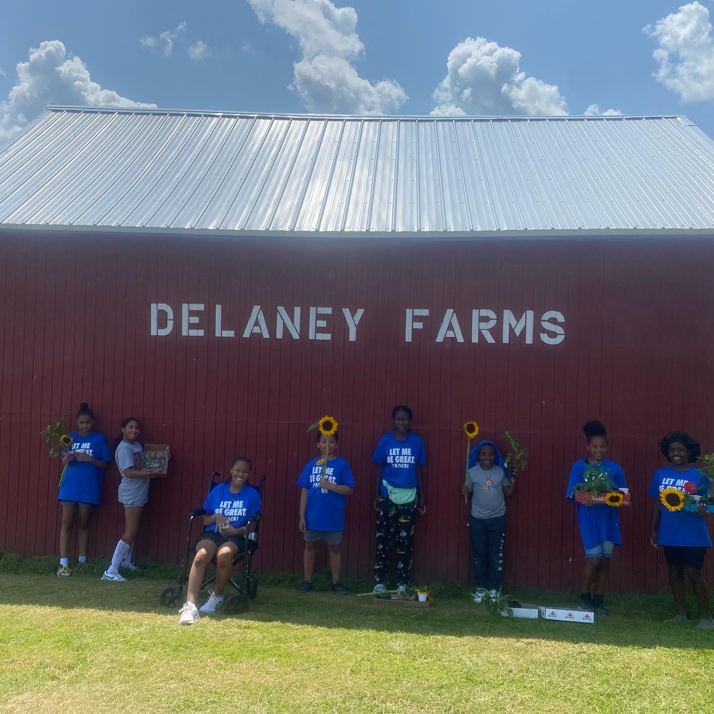 six youth standing in front of a red barn that says Delany Farms