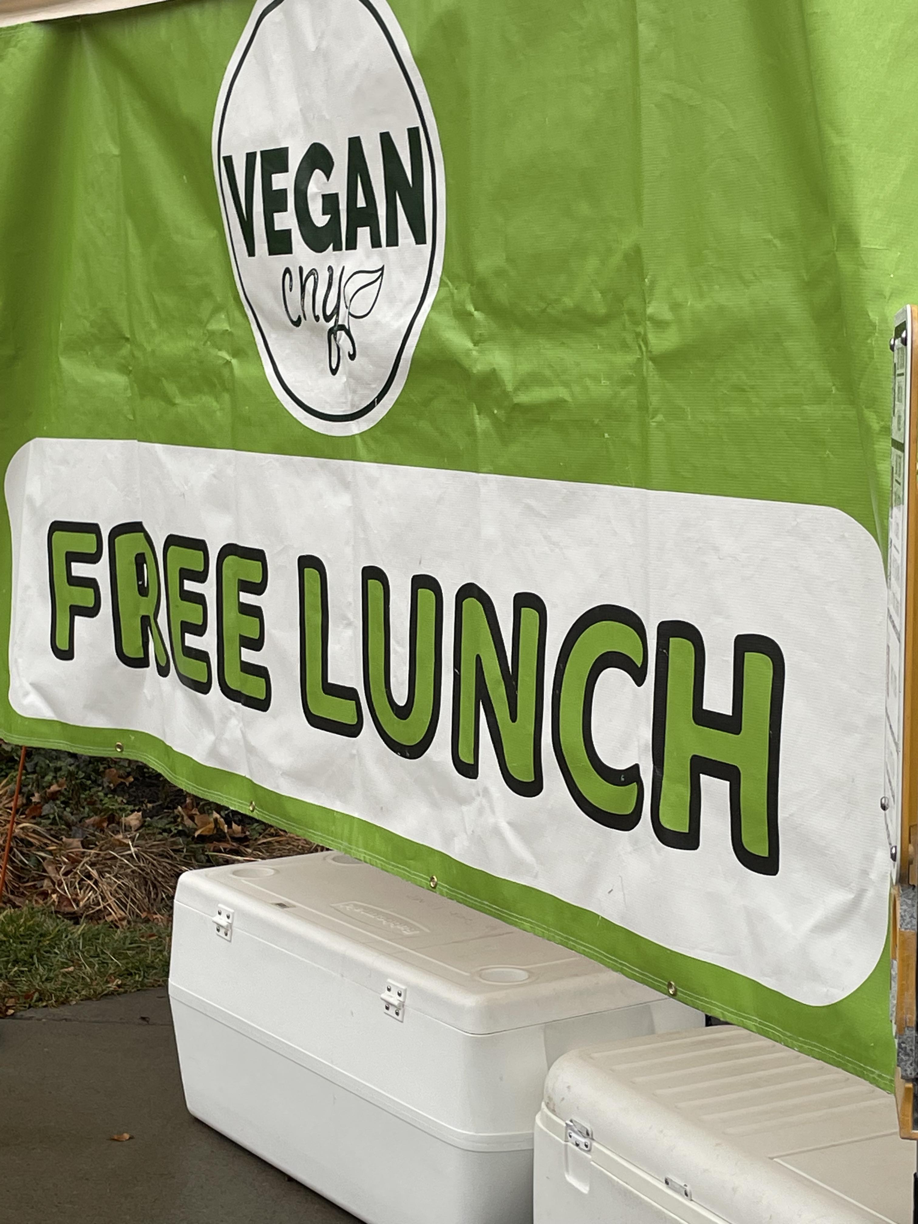 green banner that reads "Vegan CNY Free Lunch" with food coolers